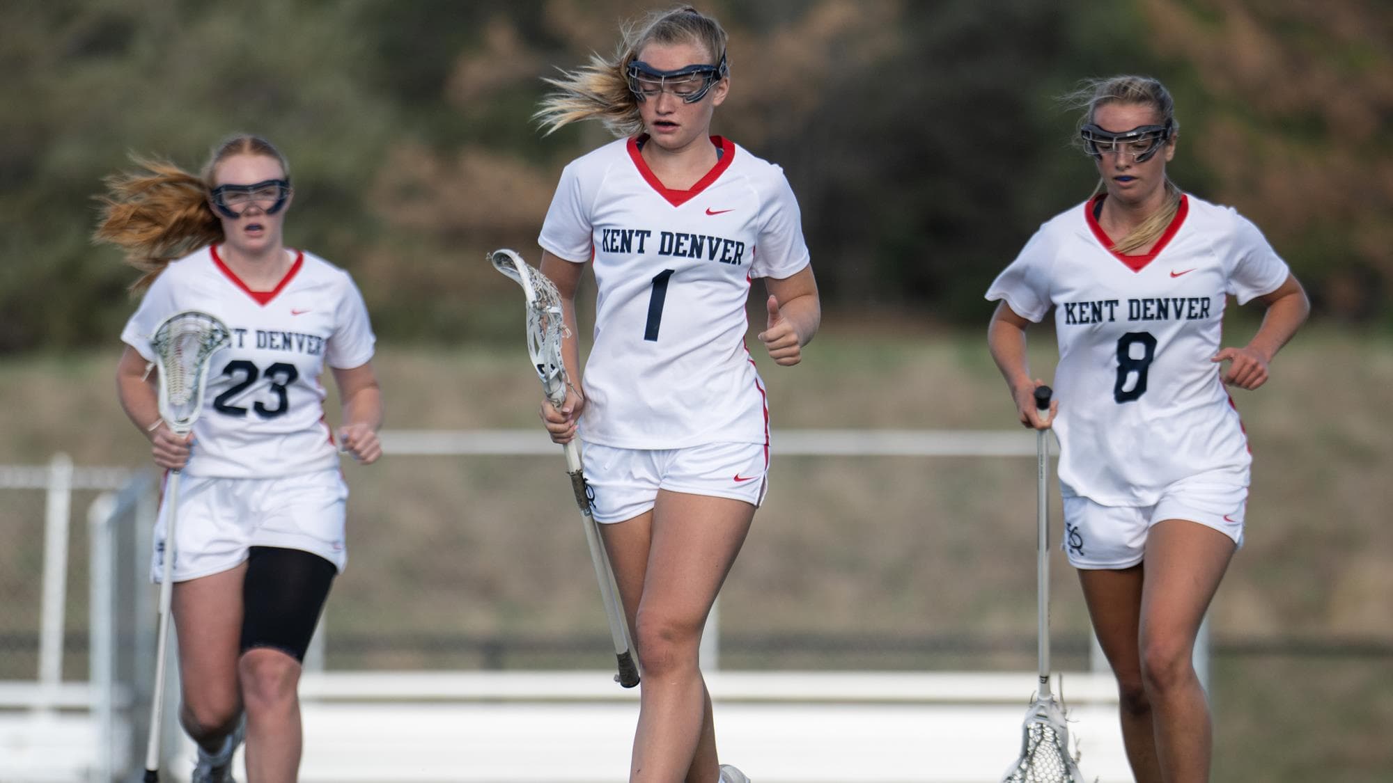 Momo Miller and two other Kent Denver players jogging while playing lacrosse